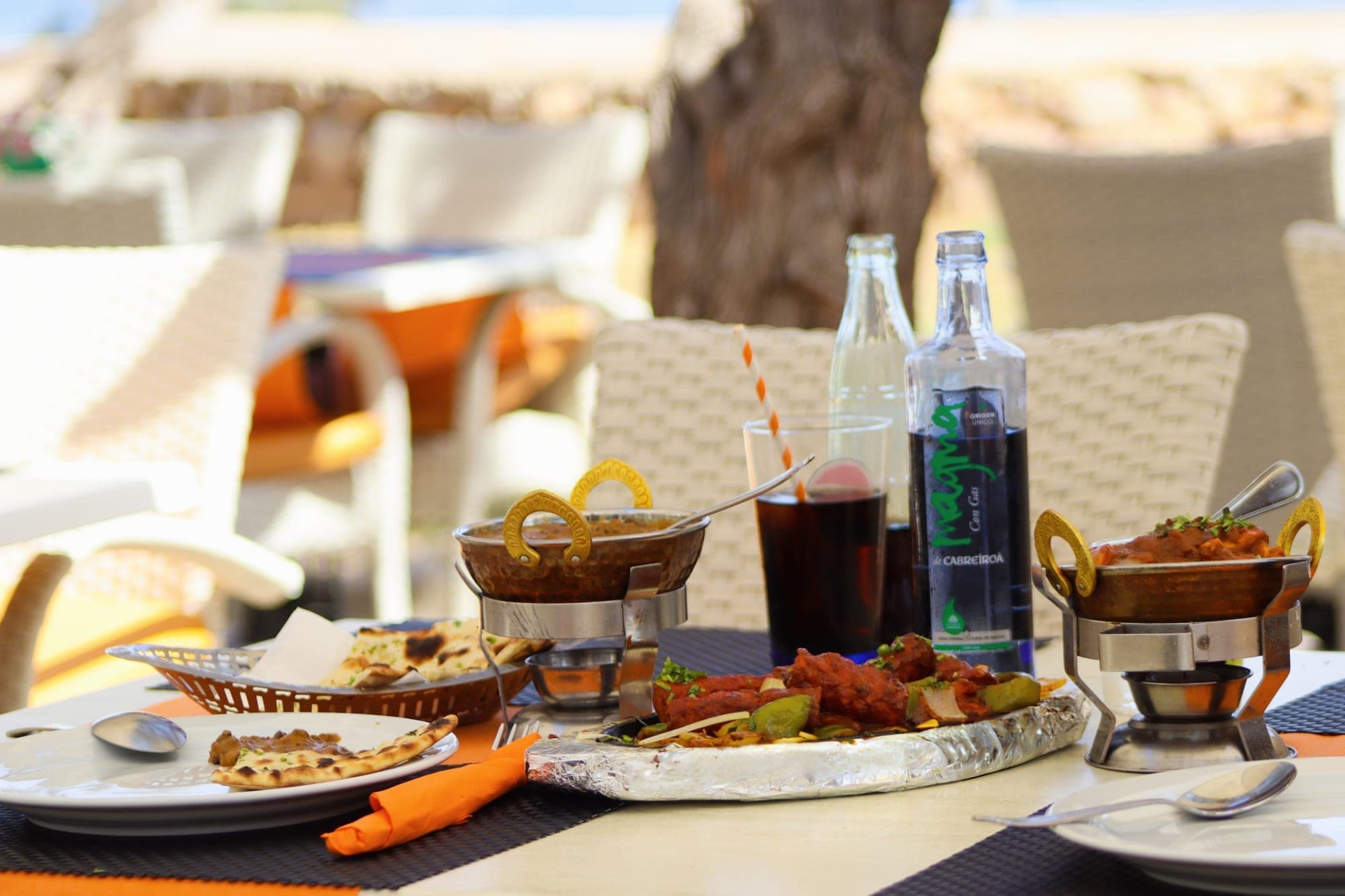 Strandterrasse des Indian Taj Cala Millor – gedeckter Tisch mit indischen Currys und Naan, Meerblick auf Mallorca